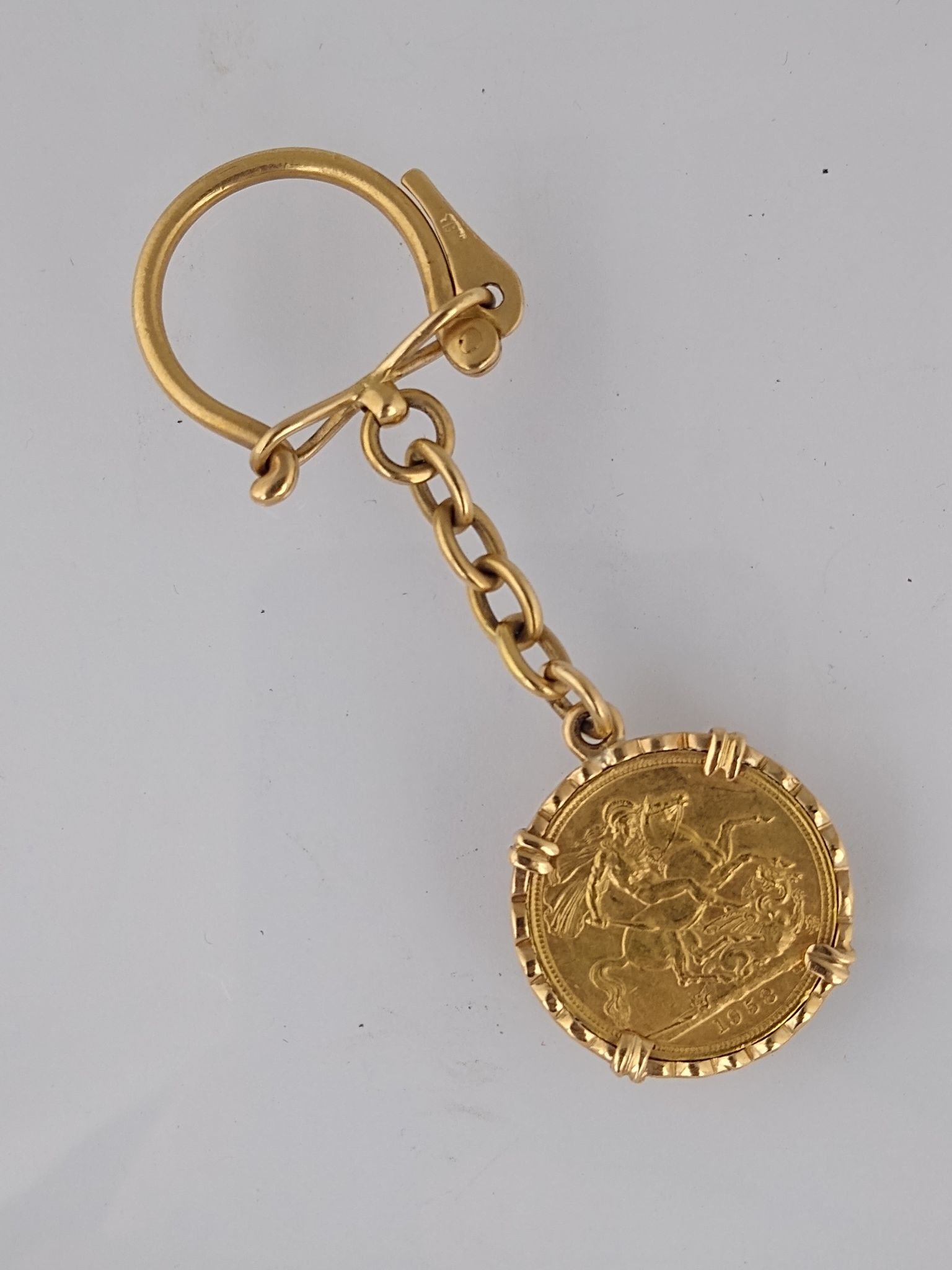 Llavero oro 18 K y libra esterlina