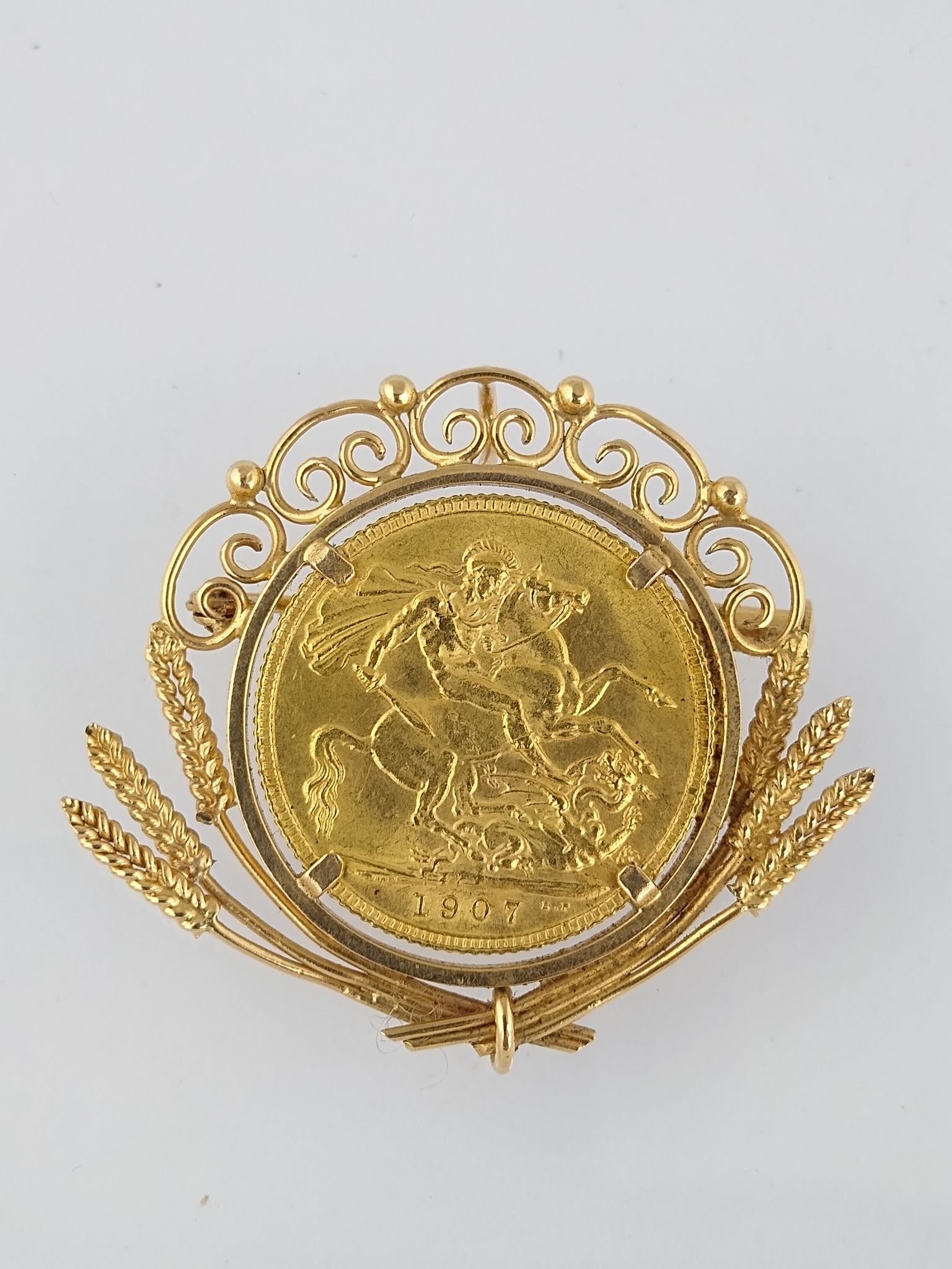Prendedor oro 18 K y libra esterlina